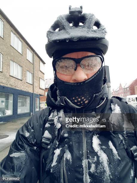 commuter on bike is covered in snow and ice on the way to work - rain face stock pictures, royalty-free photos & images