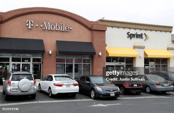 Mobile and Sprint store sit side-by-side in a strip mall on April 30, 2018 in El Cerrito, California. T-Mobile announced plans to acquire Sprint for...