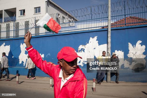 An opposition supporter waves the flag of Madagascar during an anti-government demonstration, in Antananarivo on April 30, 2018. - Opposition...