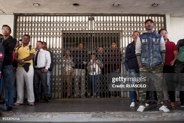 Government staff listen to the speeches of opposition activists asking them to lay down work during an anti-government demonstration, in Antananarivo...