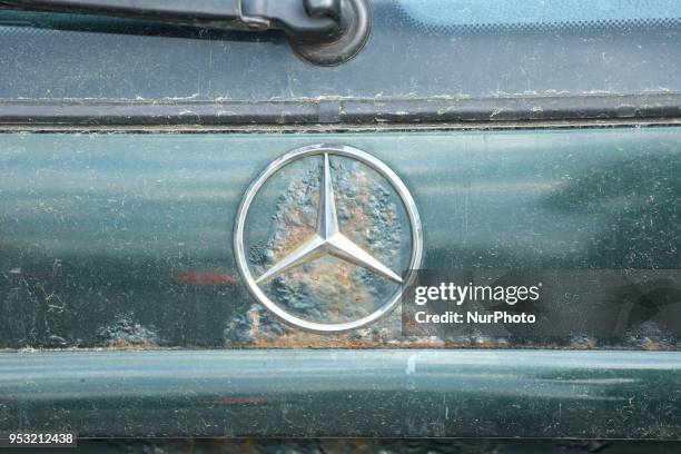 The logo of Mercedes is seen on a old and dirty car in Munich.