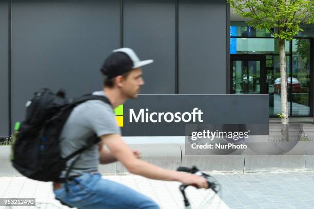 The logo of Microsoft is seen in Munich as a cyclist drives by.