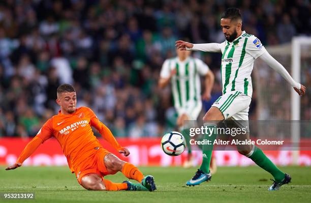 Medhi Lacen of Malaga CF competes for the ball with Ryad Boudebouz of Real Betis Balompie during the La Liga match between Real Betis and Malaga at...