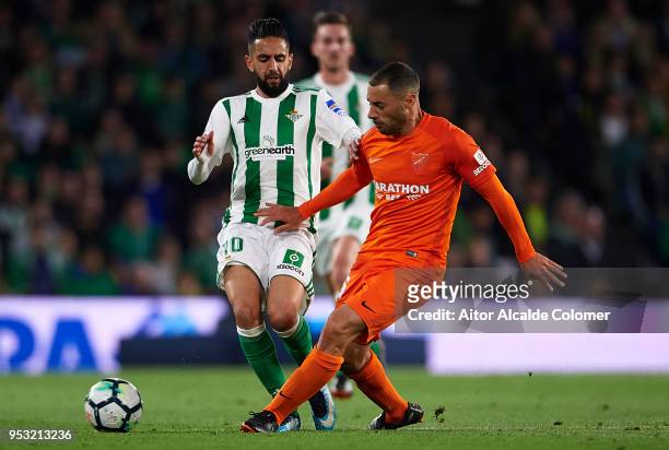 Ryad Boudebouz of Real Betis Balompie competes for the ball with Federico Ricca of Malaga CF during the La Liga match between Real Betis and Malaga...
