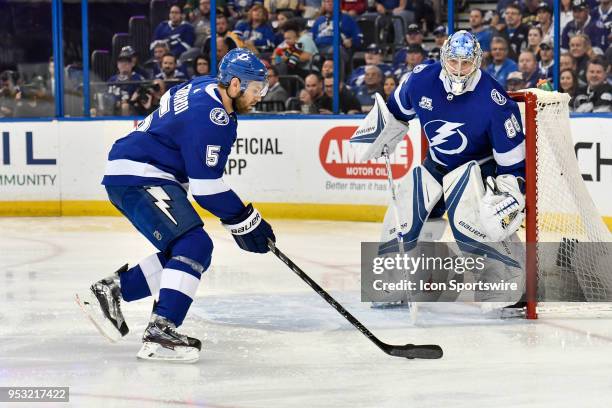 Tampa Bay Lightning defender Dan Girardi takes the puck behind his goal as Tampa Bay Lightning goalie Andrei Vasilevsky looks on during the first...