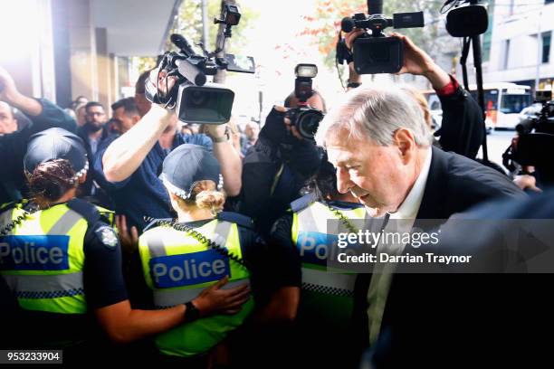 Cardinal George Pell walks through a police guard at Melbourne Magistrates' Court on May 1, 2018 in Melbourne, Australia. Cardinal Pell was charged...
