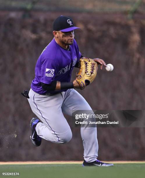 Gerardo Parra of the Colorado Rockies drops the ball allowing a run to score for the Chicago Cubs in the 2nd inning at Wrigley Field on April 30,...