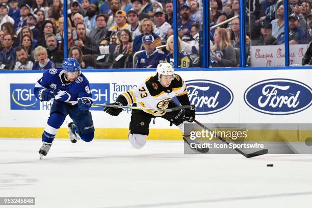 Tampa Bay Lightning center Tyler Johnson and Boston Bruins defender Charlie McAvoy race for a puck during the second period of an NHL Stanley Cup...