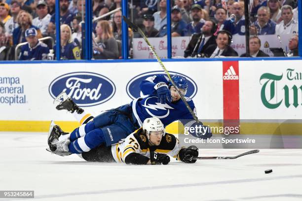 Boston Bruins defender Charlie McAvoy makes a diving poke check as he races Tampa Bay Lightning center Tyler Johnson for a puck during the second...