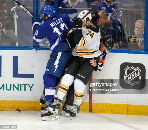 Miller of the Tampa Bay Lightning checks Jake DeBrusk of the Boston Bruins into referee Kelly Sutherland during Game Two of the Eastern Conference...