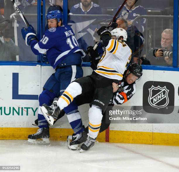 Miller of the Tampa Bay Lightning checks Jake DeBrusk of the Boston Bruins into referee Kelly Sutherland during Game Two of the Eastern Conference...