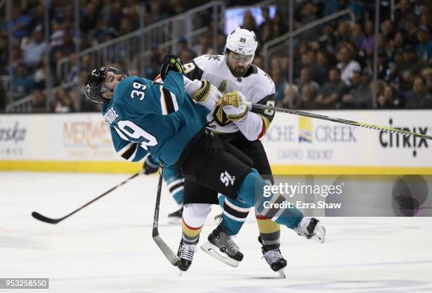 Logan Couture of the San Jose Sharks gets checked by Alex Tuch of the Vegas Golden Knights during Game Three of the Western Conference Second Round...