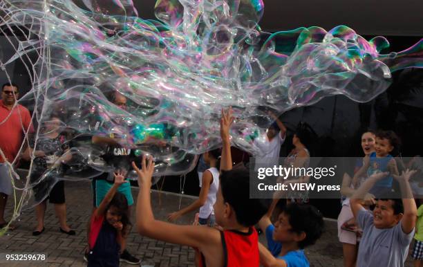Children and adults play as they make giant soap bubbles in the City Park Dom Nivaldo Monte, on April 29, 2018 in Natal.