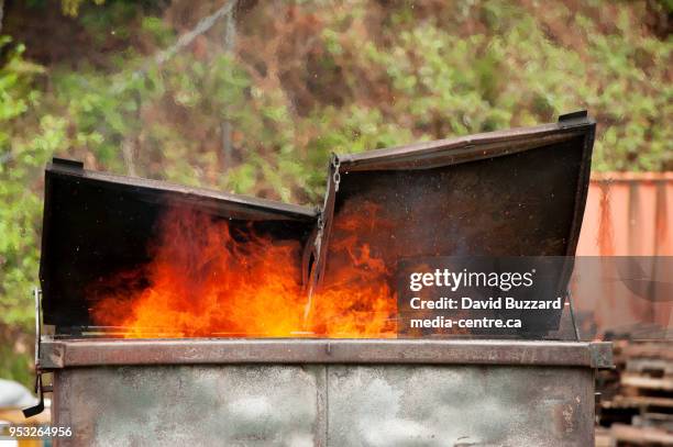 a burning dumpster fire, as part of a fire fighter's training exercise.  squamish bc, canada.  april 29, 2018. - müllcontainer stock-fotos und bilder