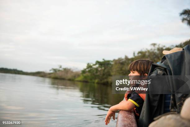 kind zit op een boot en neemt in de weergave op de amazone-rivier - amazon forest stockfoto's en -beelden