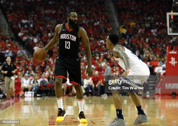 James Harden of the Houston Rockets controls the ball defended by Jeff Teague of the Minnesota Timberwolves in the first half during Game Five of the...