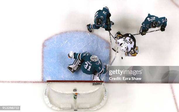 Martin Jones of the San Jose Sharks and Dylan DeMelo and Justin Braun of the San Jose Sharks stop David Perron of the Vegas Golden Knights from...