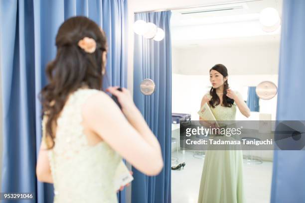 woman checks her hairstyle at backstage dressing room. - anprobekabine stock-fotos und bilder