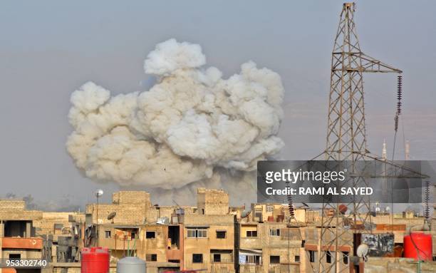 General view shows smoke rising from buildings during regime strikes on the Palestinian camp of Yarmuk and the neighbouring al-Hajar al-Aswad...