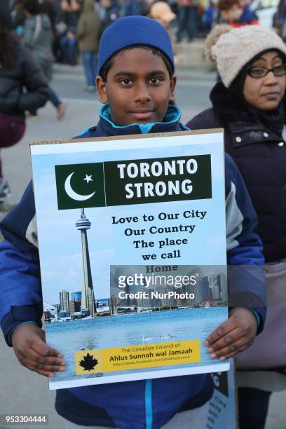 Muslim boy hold a sign saying 'Toronto Strong' as thousands of people attended an inter-faith vigil at Nathan Phillips Square in memory of the 10...