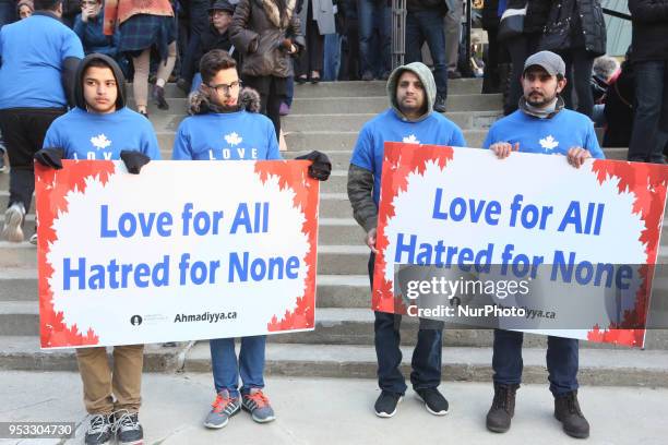 People hold signs saying 'Love for all, hatred for none' as thousands of people attended an inter-faith vigil at Nathan Phillips Square in memory of...