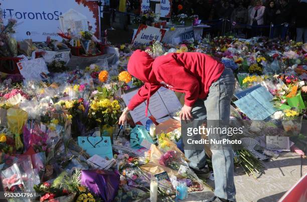 Man lighting candles at a memorial during an inter-faith vigil at Nathan Phillips Square in memory of the 10 people killed and 15 people injured in a...