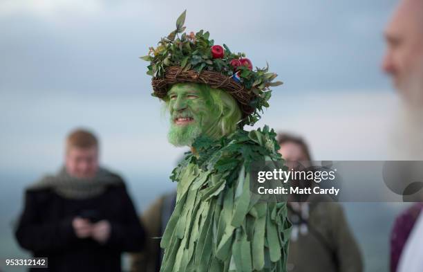 People look towards where the sun is rising as they gather on Glastonbury Tor to watch the sun rise as they celebrate Beltane on May 1, 2018 in...