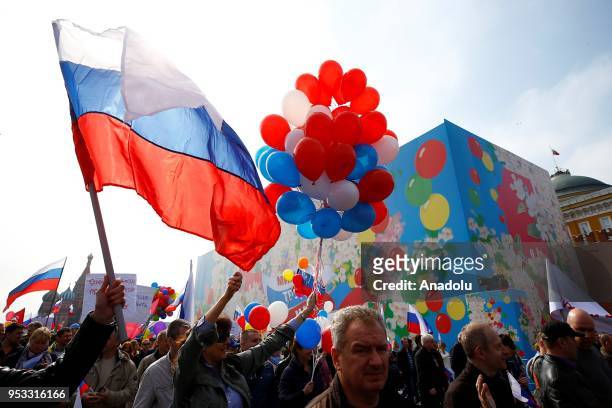 Russian people with flowers and flags take part in a rally to mark May Day, International Workers' Day, at the Red Square, in Moscow, Russia on May...