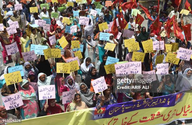 Pakistani union workers members hold placard as they march during a May Day rally in Lahore on May 1, 2018. Countries across the world celebrate May...