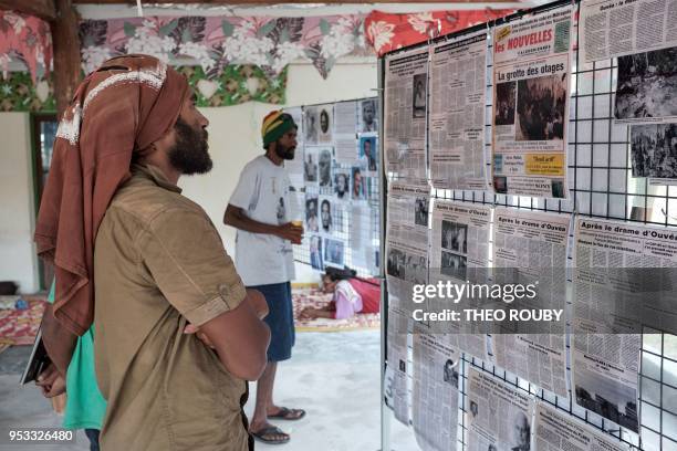 Men from the Wakatr tribe look at old newspaper clippings as part of the commemoration ceremonies in tribute to victims of the 1988 hostage crisis,...