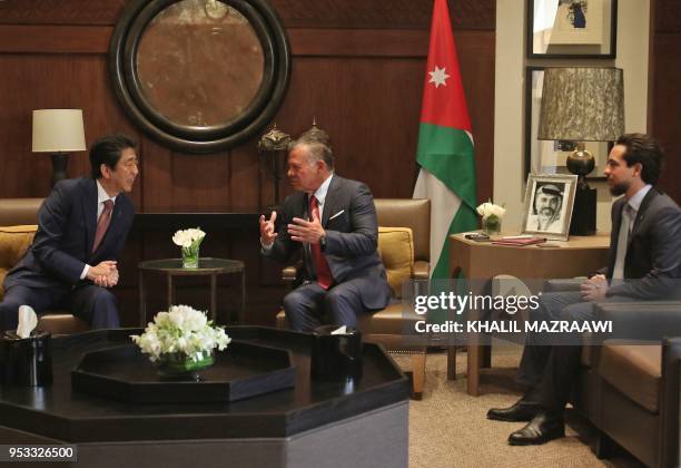 Japanese Prime Minister Shinzo Abe talks with Jordanian King Abdullah II next to the king's son Crown Prince Hussein at the Jordanian Royal Palace in...