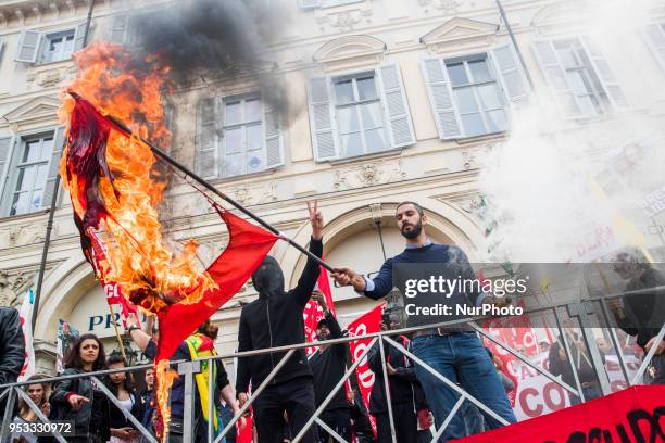 Protester sets fire to a Turkish flag during the may day rally in downtown during Mayday Commemoration in Turin, Italy, on 1st May 2018. Mayday in...