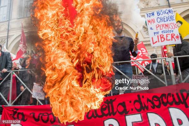 Protester sets fire to a Turkish flag during the may day rally in downtown during Mayday Commemoration in Turin, Italy, on 1st May 2018. Mayday in...