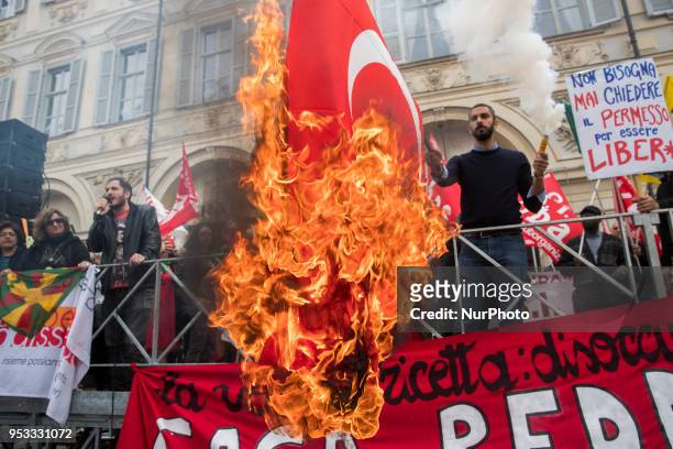 Protester sets fire to a Turkish flag during the may day rally in downtown during Mayday Commemoration in Turin, Italy, on 1st May 2018. Mayday in...