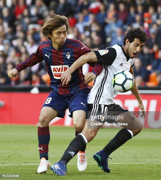 Valencia's Dani Parejo shields the ball against Eibar's Takashi Inui during the second half of a scoreless draw in the Spanish La Liga in Valencia,...