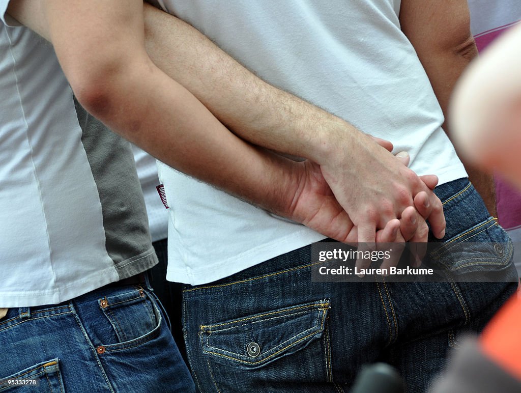 Gay Couple Holds Hands behind back 