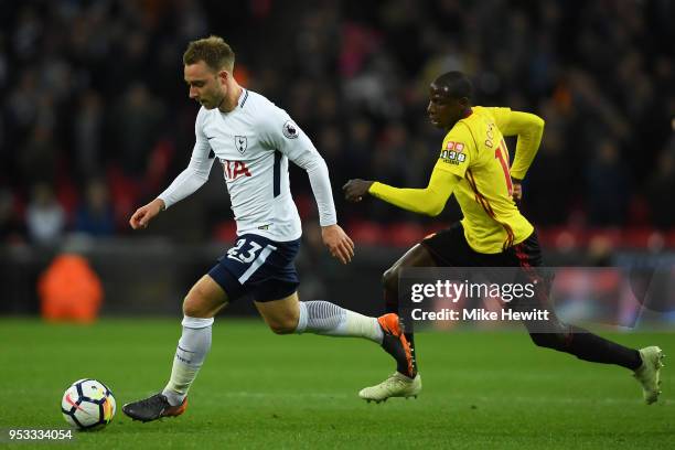 Christian Eriksen of Tottenham Hotspur is chased by Abdoulaye Doucoure of Watford during the Premier League match between Tottenham Hotspur and...