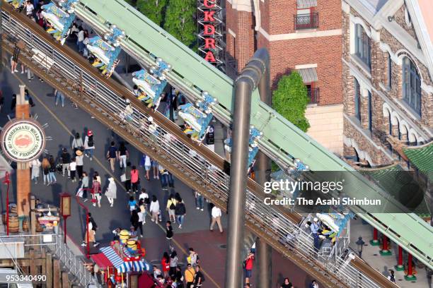 In this aerial image, passengers of rollercoaster Flying Dinosaur are hung in the air after the emergency stop at the Universal Studio Japan on May...