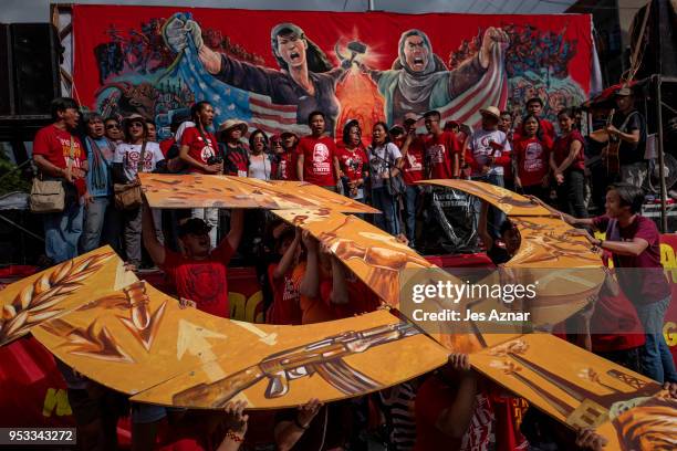 Workers and activists display a hammer and sickle sign as they sing the Internationale on mark Labor Day on May 1, 2018 in Manila, Philippines....