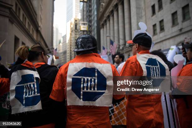 Activists, wearing orange prison jumpsuits with the Chase Bank logo, rally against financial institutions' support of private prisons and immigrant...