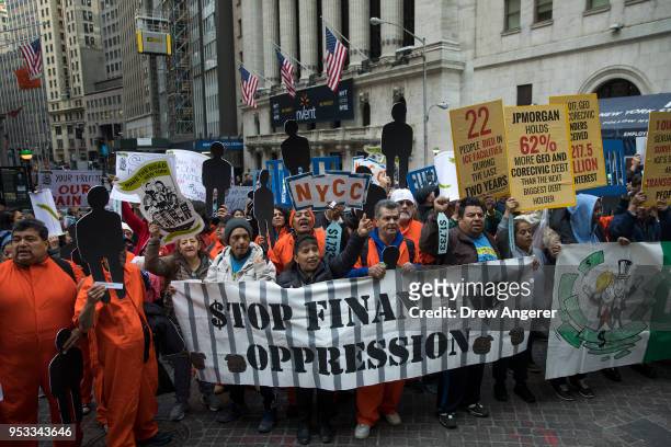 Activists rally against financial institutions' support of private prisons and immigrant detention centers, as part of a May Day protest near Wall...