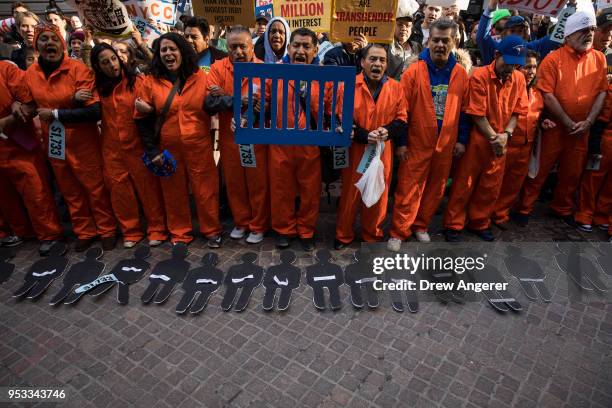 Activists rally against financial institutions' support of private prisons and immigrant detention centers, as part of a May Day protest near Wall...