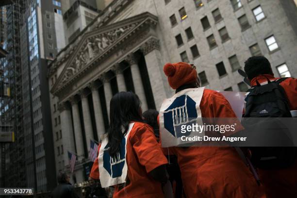 Activists, wearing orange prison jumpsuits with the Chase Bank logo, rally against financial institutions' support of private prisons and immigrant...
