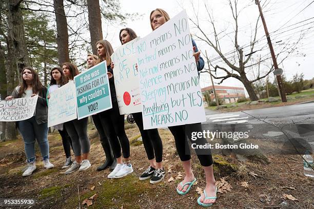 Students hold signs as they take part in a walkout at Lincoln-Sudbury Regional High School in Sudbury, MA on April 30, 2018 in response to the...