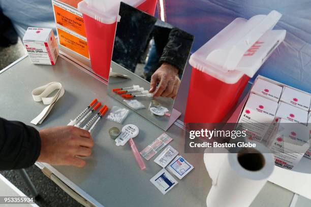 Visitor to a mock safe injection site set up by SIF MA NOW at Harvard School of Public Health checks out the items on the demonstration table set up...