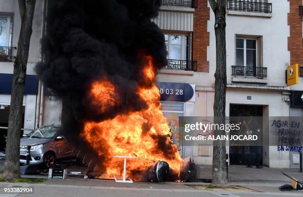 Car and a motorbike burn during a demonstration on the sidelines of a march for the annual May Day workers' rally in Paris on May 1, 2018.