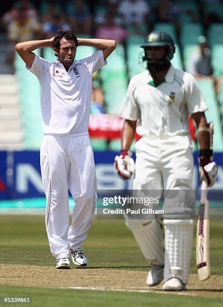 Graham Onions of England looks on as Hashim Amla of South Africa turns around during day one of the second test match between South Africa and...