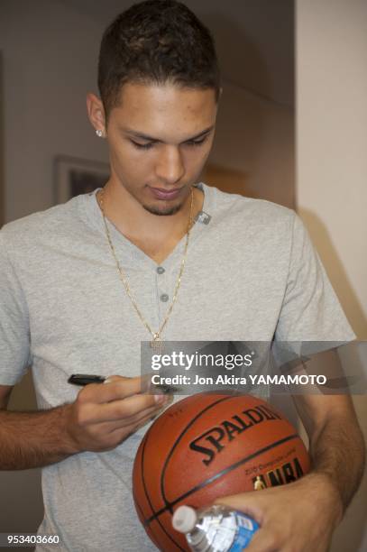 Denver Nuggets player Evan Fournier signs a basketball for a drawing at an open house conducted by the Alliance Francaise of Denver on September 8,...