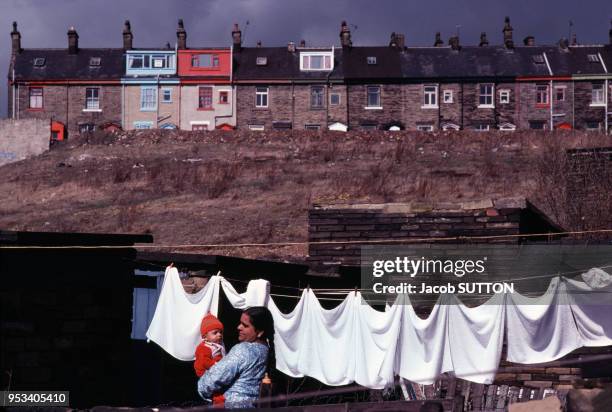 Une femme pakistanaise et son bébé étend son linge dans le quartier résidentiel de Bradford, en juin 1978, dans le Yorkshire, Royaume-Uni.