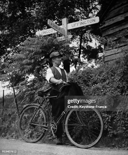 Evans, spécialiste de la rénovation des toits en chaume, à côté de son vélo dans un petit village de la campagne anglaise à Woolstone, Royaume-Uni.